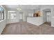 Open-concept living room with neutral paint and carpet flooring leading to a kitchen and dining area at 11154 W Ashley Chantil Dr, Surprise, AZ 85378