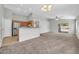 Open-concept living room flows into the kitchen, featuring neutral tones and access to the outdoor space at 11154 W Ashley Chantil Dr, Surprise, AZ 85378