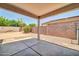 A covered patio featuring concrete flooring, sturdy support pillars, and views of the backyard landscaping at 11154 W Ashley Chantil Dr, Surprise, AZ 85378