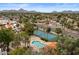This aerial view features the pool, tennis court, nearby landscaping, and tropical palm trees at 11633 N 40Th Way, Phoenix, AZ 85028