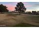 Lush golf course landscape showcasing mature trees against a vibrant sunset sky at 11633 N 40Th Way, Phoenix, AZ 85028
