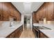 Galley kitchen with sleek stainless appliances, marble countertops, and plentiful wooden cabinets and hardwood floors at 11633 N 40Th Way, Phoenix, AZ 85028