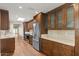 Modern kitchen with stainless steel appliances, marble countertops, custom wooden cabinets, and hardwood floors at 11633 N 40Th Way, Phoenix, AZ 85028