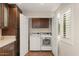 Bright laundry area featuring washer and dryer, built-in cabinets, hardwood floors, and plantation shutters at 11633 N 40Th Way, Phoenix, AZ 85028