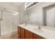 Well-lit bathroom boasts dual sinks, a large mirror, and a glass-enclosed shower for a luxurious feel at 11702 W Lincoln St, Avondale, AZ 85323