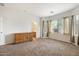 Spacious bedroom featuring neutral carpet, plenty of natural light, and a view to an en-suite bathroom at 11702 W Lincoln St, Avondale, AZ 85323