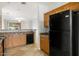 Kitchen boasts wood cabinets, tile floors, and black appliances, including a refrigerator at 11702 W Lincoln St, Avondale, AZ 85323