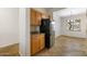 Kitchen with wood cabinets, tile floors, black appliances, including a refrigerator at 11702 W Lincoln St, Avondale, AZ 85323