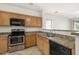 Kitchen with stainless steel oven, microwave, wood cabinets and tile floor at 11702 W Lincoln St, Avondale, AZ 85323