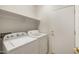 Functional laundry area with a washer, dryer, and shelving for storage to maximize organization at 11702 W Lincoln St, Avondale, AZ 85323