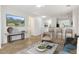 Staged living room with tile floors, neutral paint, ceiling fan, and breakfast bar to the kitchen at 11702 W Lincoln St, Avondale, AZ 85323