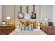 Close up of a stylishly decorated bedroom, highlighting electric guitars, stylish lamps, and decorative pillows at 11948 E Aster Ln, Florence, AZ 85132