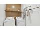 A laundry room equipped with modern white appliances, storage shelf, and hanging rack at 11948 E Aster Ln, Florence, AZ 85132