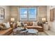 Cozy living room with a comfortable brown sofa, accent pillows, and a bright window at 11948 E Aster Ln, Florence, AZ 85132