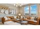 Bright living room featuring a modern chandelier, neutral color palette and comfortable brown sofa at 11948 E Aster Ln, Florence, AZ 85132