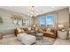 Cozy living room with a plush sofa, ottoman, stylish lighting, and modern decor at 11948 E Aster Ln, Florence, AZ 85132