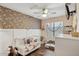 Charming Bedroom with stylish wallpaper, a crib filled with stuffed animals and a window at 13320 N 82Nd Dr, Peoria, AZ 85381