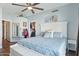 Bright bedroom featuring a large bed, ceiling fan, closet, and neutral decor at 13320 N 82Nd Dr, Peoria, AZ 85381