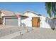 Inviting home featuring a gray garage door, a wood gate, and desert landscaping at 13320 N 82Nd Dr, Peoria, AZ 85381