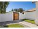 Charming home featuring a wooden gate, gravel, desert landscaping, and bright blue sky at 13320 N 82Nd Dr, Peoria, AZ 85381