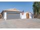 Beautiful single-story home showcasing a gray garage door, white exterior, and tiled roof at 13320 N 82Nd Dr, Peoria, AZ 85381