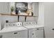Functional laundry area featuring a washer, dryer, stylish shelf decor, and overhead cabinets at 13320 N 82Nd Dr, Peoria, AZ 85381