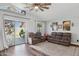 Comfortable living room with wood floors, ceiling fan, and sliding glass doors to the backyard at 13320 N 82Nd Dr, Peoria, AZ 85381