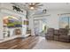 Cozy living room with wood floors, ceiling fan, a decorative display, and access to the patio at 13320 N 82Nd Dr, Peoria, AZ 85381