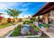 Beautiful backyard featuring lush landscaping, a covered patio, and mature trees at 1409 S Revere --, Mesa, AZ 85210