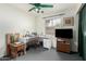 Well-lit bedroom with ceiling fan, large window, and bright white L-shaped desk at 1409 S Revere --, Mesa, AZ 85210