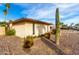 Side view of home showcasing desert landscaping, a Saguaro Cactus, and palm trees at 1409 S Revere --, Mesa, AZ 85210