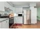 Bright kitchen with white cabinetry, stainless steel appliances, and laminate flooring at 1409 S Revere --, Mesa, AZ 85210