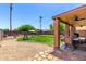 Fenced backyard with lawn, covered patio and play area at 15427 W Port Au Prince Ln, Surprise, AZ 85379
