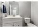 Charming powder bathroom with modern fixtures, vanity and neutral gray walls at 15427 W Port Au Prince Ln, Surprise, AZ 85379