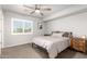 Comfortable bedroom features soft gray walls, carpeted floors, and a ceiling fan at 15427 W Port Au Prince Ln, Surprise, AZ 85379