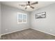 Neutral bedroom with carpet, ceiling fan, and bright window at 15427 W Port Au Prince Ln, Surprise, AZ 85379