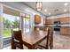 Open-concept dining area adjacent to the kitchen, featuring a large wooden table and sliding glass doors leading to the backyard at 15427 W Port Au Prince Ln, Surprise, AZ 85379