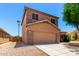Two-story home boasts a two-car garage and low-maintenance desert landscaping in the front yard at 15427 W Port Au Prince Ln, Surprise, AZ 85379