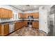 Well-lit kitchen featuring stainless steel appliances, wooden cabinets, tile flooring, and light countertops at 15427 W Port Au Prince Ln, Surprise, AZ 85379