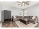 Inviting living room features a plush sectional sofa, stylish rug, and a ceiling fan at 15427 W Port Au Prince Ln, Surprise, AZ 85379