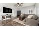 Comfortable living room with a plush gray couch, ceiling fan, modern furnishings, and neutral gray walls at 15427 W Port Au Prince Ln, Surprise, AZ 85379