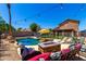 Backyard pool and spa with rock waterfall feature and lounge area at 15427 W Port Au Prince Ln, Surprise, AZ 85379