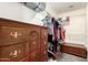 Spacious walk-in closet with shelving, hanging space, and vintage dresser at 15427 W Port Au Prince Ln, Surprise, AZ 85379