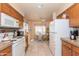 Traditional eat-in kitchen with wood cabinets, white appliances, and tile flooring at 17342 E Quail Ridge Dr, Fountain Hills, AZ 85268