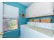 Bright laundry room with built in cabinets, a large window, and included washer/dryer at 17342 E Quail Ridge Dr, Fountain Hills, AZ 85268
