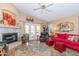 Cozy living room with fireplace, ceiling fan, and access to outdoor area with French doors at 17342 E Quail Ridge Dr, Fountain Hills, AZ 85268