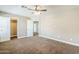 Large bedroom with multiple entry doors, ceiling fan, and soft carpet, offering space and comfort at 1839 E Parkside Ln, Phoenix, AZ 85024