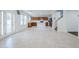 Spacious open-concept living area with modern tile floors leading to the kitchen and staircase at 1839 E Parkside Ln, Phoenix, AZ 85024