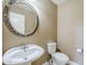 Stylish powder room with a pedestal sink, round mirror, and modern fixtures at 1839 E Parkside Ln, Phoenix, AZ 85024
