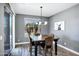 A dining area with a table, chairs, a modern light fixture, and a sliding glass door with backyard view at 18429 W Mauna Loa Ln, Surprise, AZ 85388